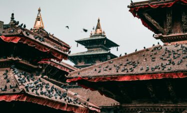 Pigeons on traditional pagoda rooftops in cultural Kathmandu, Nepal.
