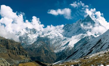 Majestic snow-capped peaks of Annapurna in clear daylight, perfect for outdoor enthusiasts.