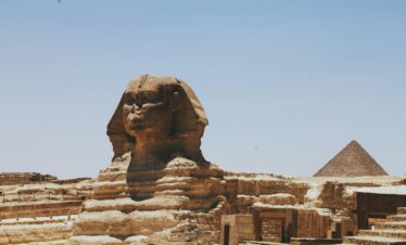 View of the Great Sphinx of Giza and Pyramid, iconic Egyptian landmarks in daylight.