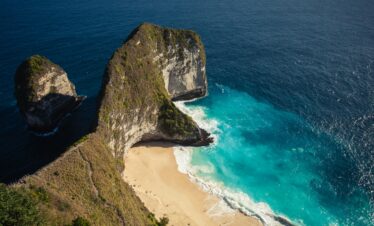Stunning aerial view of the iconic Kelingking Beach in Bali, showcasing turquoise waters and dramatic cliffs.